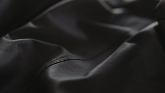 Slow motion handheld shot of soft gray leather jacket