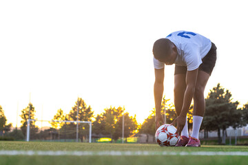 Football player placing the ball on the grass. Low angle of football player putting the ball on the...