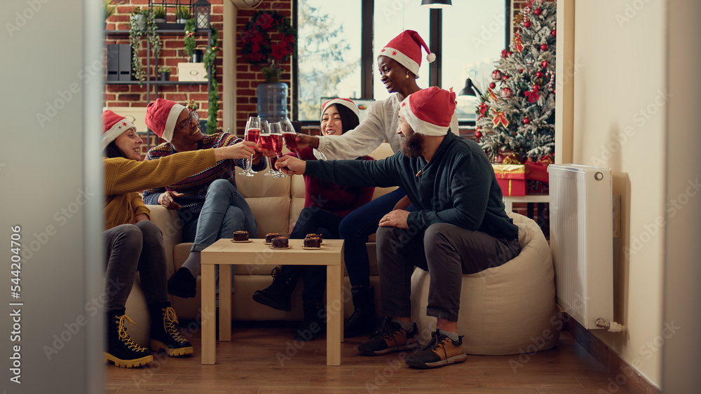 Wall mural diverse coworkers toasting with glasses of wine at christmas holiday in decorated office. people cli