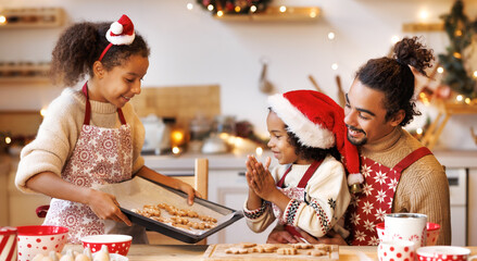 Happy ethnic family father and kids making cookies on kitchen at christmas time