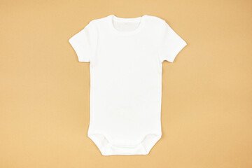 White baby girl or boy bodysuit mockup flat lay on craft paper background. Design onesie template,...