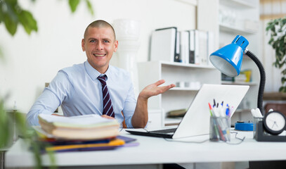 Portrait of successful middle aged businessman at workplace in modern office