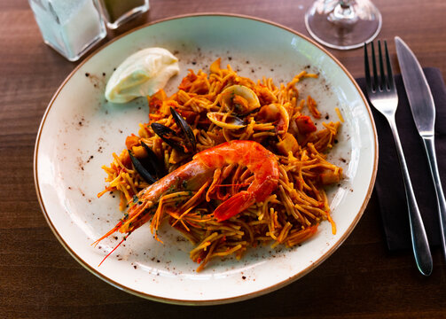 Traditional seafood fideua with mussels, calamari and shrimps served with aioli