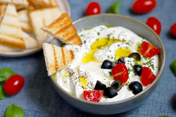 Greek yogurt dip with olives and croutons.