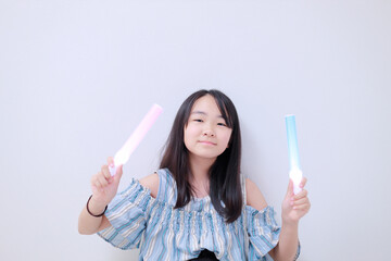 	ペンライトを両手に持ちポーズをとる少女