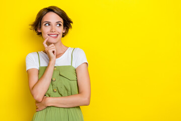 Photo of charming girl bite lips finger touch cheeks minded looking empty space choosing new...