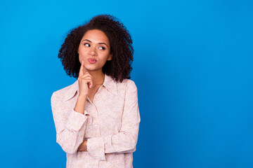 Portrait of creative attractive person finger touch chin look empty space decide isolated on blue...