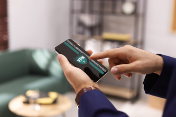Man using smartphone with switched on VPN in office, closeup