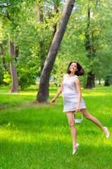 Young smiling woman picking flowers on the summer meadow
