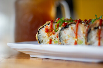 Asian sushi roll with toppings and vegetables. Filled with crab, avocado, cucumber and sauce.