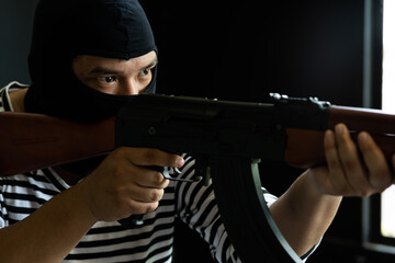 Masked robber with gun. Concept of crime and fire arm assault with mature man. Armed robbery on...