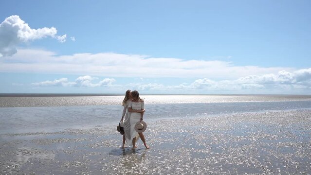 country lesbian brides dancing and kissing on beach on wedding day