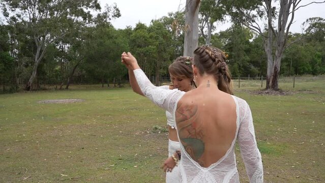 country lesbian brides dancing and kissing at farm on wedding day
