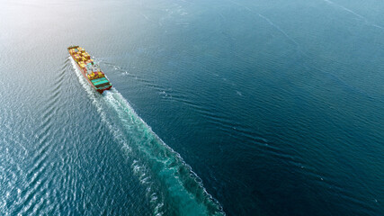 cargo maritime ship with contrail in the ocean ship carrying container and running for export...