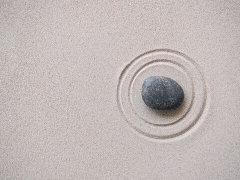 Zen Garden japanese with White Pebble and Texture Line on Sand Background,Top View Rock on Sand Symbols Meditation Still Religion Janpan,Nature Balance Circle Rock for Spa and Calm Buddhism Concept.
