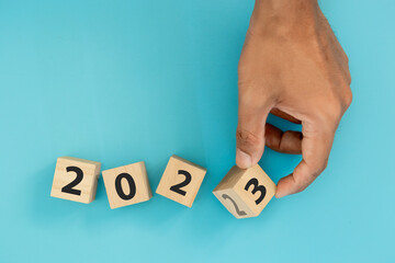 Hand holding wooden cube blocks change 2022 to 2023. New year 2022- 2023. business goals next year. new year 2023 concept.