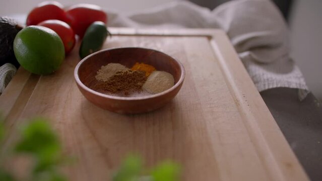 Woman preparing spices in mixing bowl, modern kitchen
