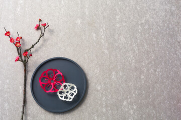 梅の花の造花とお盆の上に置かれた紙で作られた梅の花