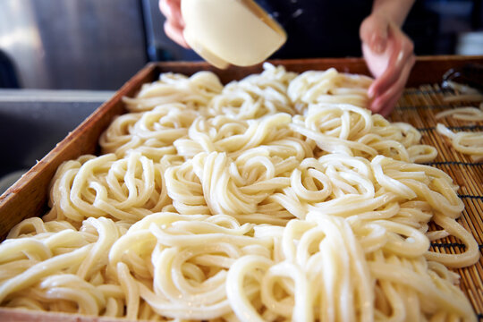 茹でたうどんの麺を並べている工程写真