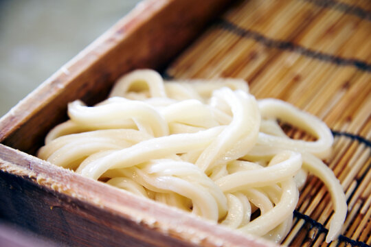 茹でたうどんの麺を並べている工程写真
