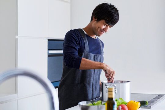 キッチンで料理する男性