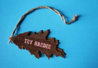 Leather tag with text TRY HARDER , concept of self motivation to never give up - being persistent , work harder do better and if it fails, try again