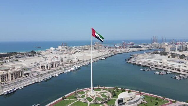 Aerial view: The Flag of the United Arab Emirates waving in the air over Sharjah's Flag Island, UAE National Day celebrations, 4K