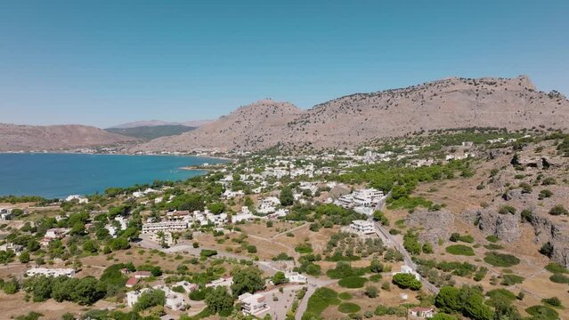 Drone pullback over remote beach resort on Rhodes Island - Pefkos, Greece