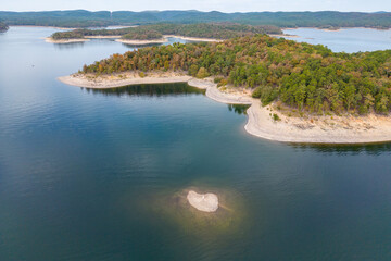 Fototapeta na wymiar Aerial view of landscape of water of Broken Bow lake and islands with forest on the bank, Oklahoma, USA. Autumn scenery of coastal line.