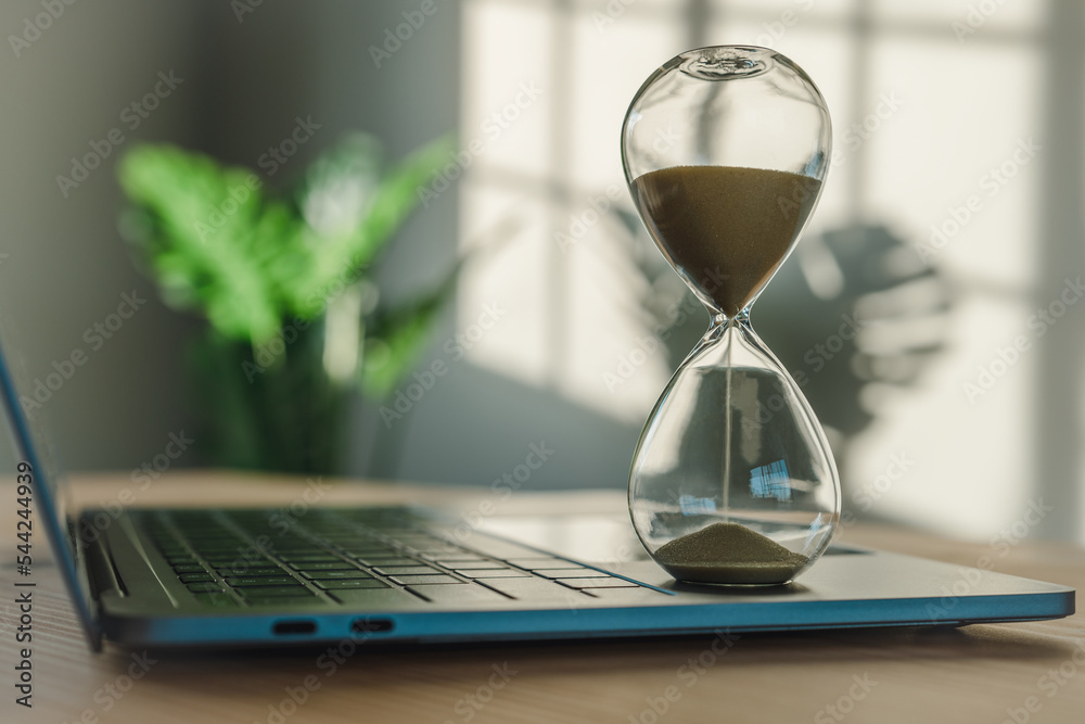 Aufkleber concept of an hourglass on a laptop computer for time management and deadline counting