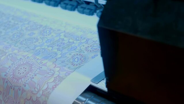 The industrial printer, plotter head slides over the surface of the paper and prints a large image. Closeup