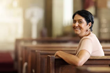 Fotobehang Senior woman, christian and happy in church, spiritual and religion after service, smile and lifestyle. Elderly female smile, portrait and empowerment while sitting in wood bench in catholic chapel © David L/peopleimages.com
