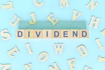 Dividend concept in finance and investing. Word typography on wooden blocks flat lay.