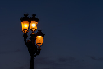 Fototapeta na wymiar An illuminated streetlight during sunset with copy space