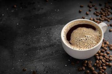 Coffee background, top view with copy space. White cup of coffee, ground coffee, coffee beans on dark wooden background