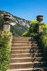 The old stairs and columns inside the botanical garden of the famous Villa Monastero in Varenna, Province of Lecco, Italy.