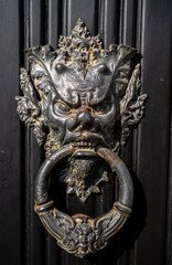 Fascinating door knocker in the shape of head on one of the entrance doors to the historic Villa Monastero, the villa of lords, Varenna, Province of Lecco, Italy.