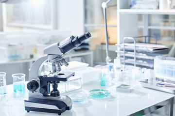 Workplace of virologist or other scientist with microscope and glassware necessary for new...