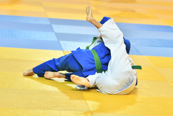 Fighter girls in judogi compete in judo on the tatami