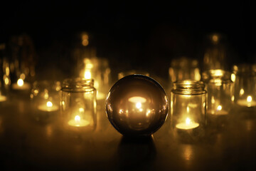 Black background with a ball and candles. Divination and prediction of fate.