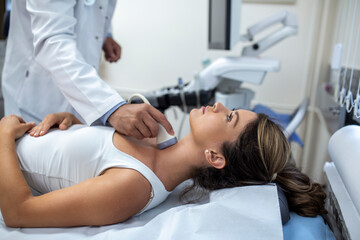 Man endocrinologist making ultrasonography to a female patient in an ultrasound office. Ultrasound...