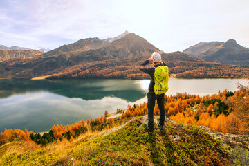 Man observes autumn landscape at a mountain lake - 544269729