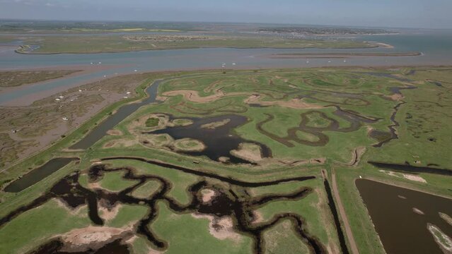 Marshes And Creek In Tollesbury On The Coastline Of Essex In The UK. aerial sideways