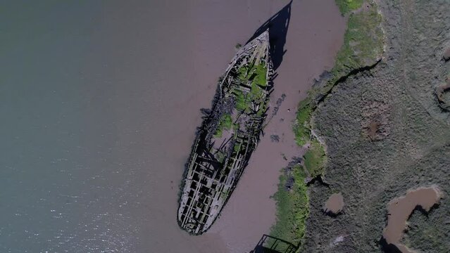 Drone Ascending Over Ruined Ship In Salt Marshes At Tollesbury Marina, Essex, United Kingdom. Aerial Rotating