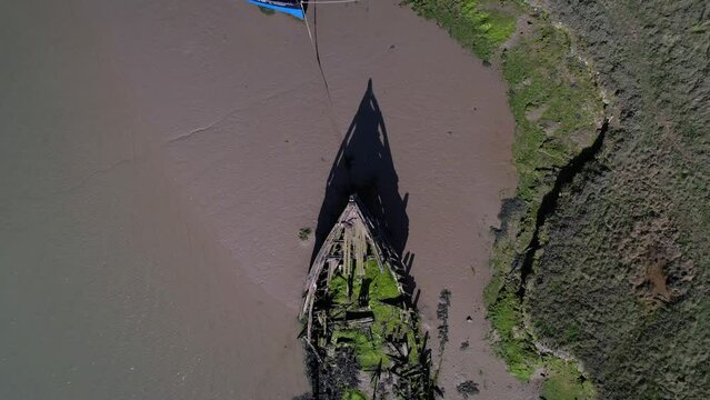 Destroyed Ship Deserted Near The Salt Marshes In Tollesbury Marina, Essex, United Kingdom. Aerial Drone Shot