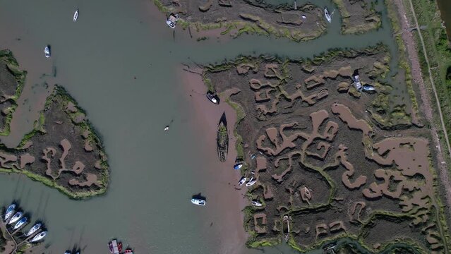 Overhead View Of Ruined Ship Abandoned On Wetlands In Tollesbury Marina, Essex, England UK. Aerial Drone Shot