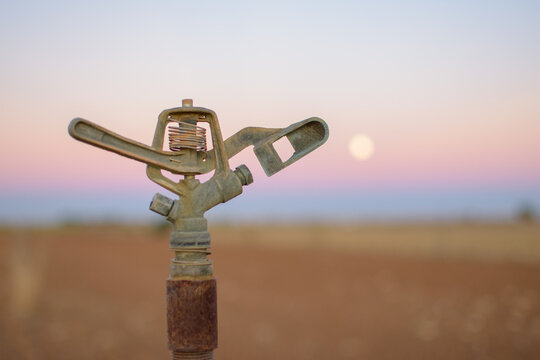 aspersor con luna de fondo