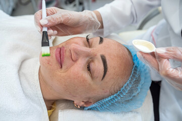 close-up of a beautician doing rejuvenating procedures for a client's face in a spa or salon.