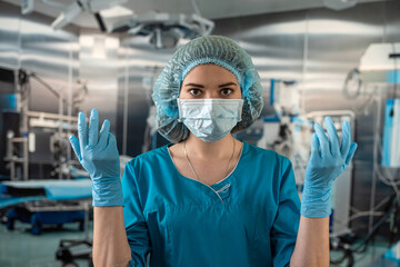 Fototapeta na wymiar doctor or nurse in coat puts on blue rubber gloves prepares examine patient in operating room.