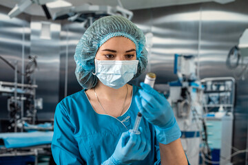 Fototapeta na wymiar doctor wearing blue uniform with glove full virus protection holding syringe with medicine